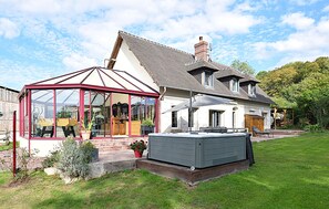 A house with a conservatory, a hot tub, and a well-maintained lawn. - Piscine, spa et littoral (SAINT-ANDRE-D'HERBERTO)