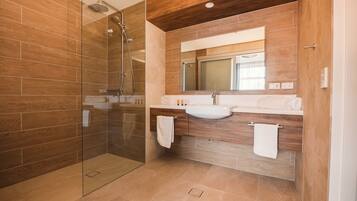 Un bagno moderno con cabina doccia in vetro, pannelli in legno e un mobile lavabo con specchio e lavandino.