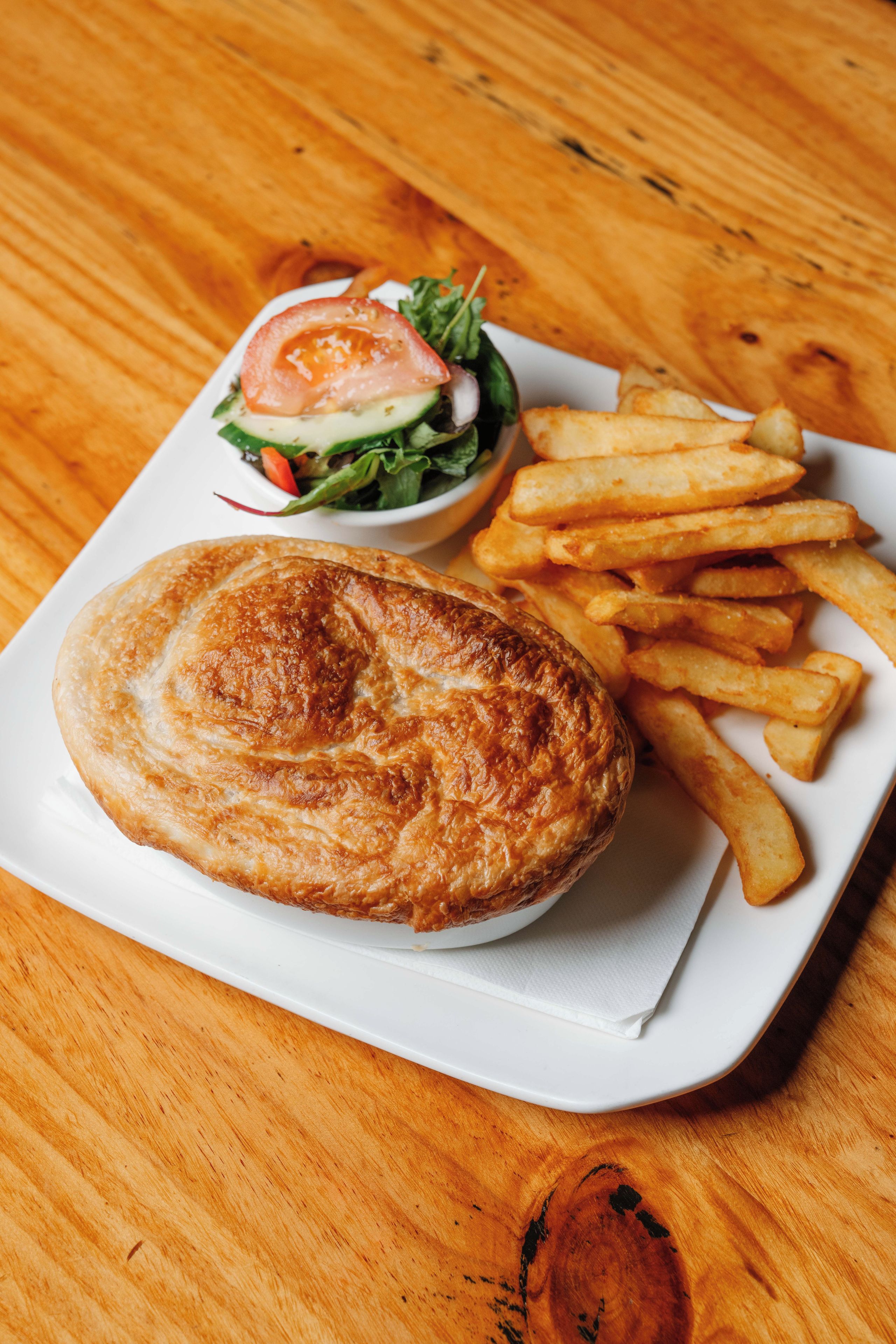 Une assiette avec une pâtisserie, des frites et une salade.
