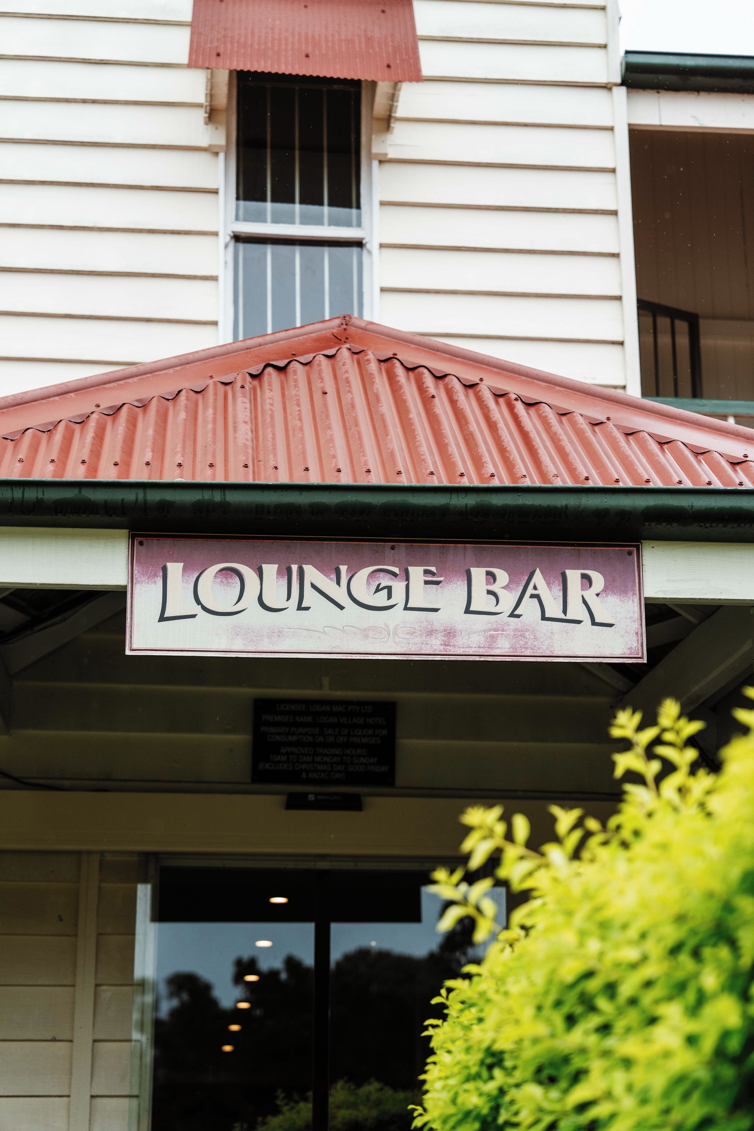 Un edificio con un letrero que dice 'LOUNGE BAR' sobre la entrada.