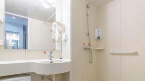 A bathroom with a sink, mirror, towel rack, shower, and a soap dispenser. - Jinjiang Inn (Weihai)