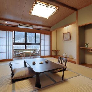 A traditional Japanese room with tatami flooring, a low table with tea sets, and sliding shoji doors. - Tanigawa Hotel Nanaeyae (Nikko)