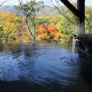 A hot spring with a wooden structure and a view of autumn foliage. - Tanigawa Hotel Nanaeyae (Nikko)