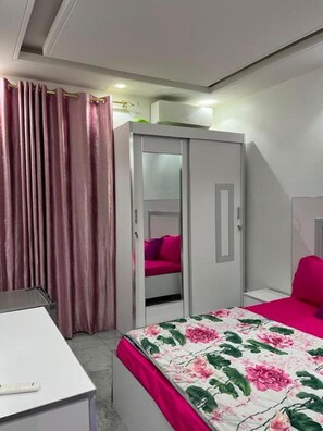 Een slaapkamer met een bed, een kledingkast, een bureau en een stoel.