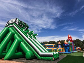 Un espace de jeux gonflable comprenant diverses structures, notamment un toboggan et une maison de jeux en forme de château.