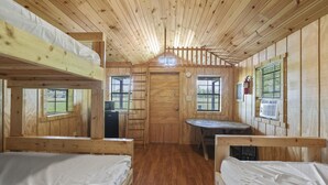 A cabin with bunk beds, a small kitchenette, and a dining table. - Yeti Rustic Cabin - Yeti Rustic Cabin rates are based on 4 guests, maximum of 6 guests (Rockbridge)