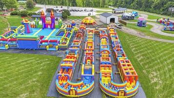 An aerial view of an amusement park with various inflatable play structures and a parking lot.