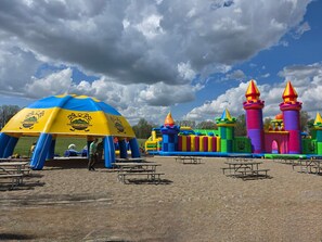 A family fun center with inflatable play structures and picnic tables.