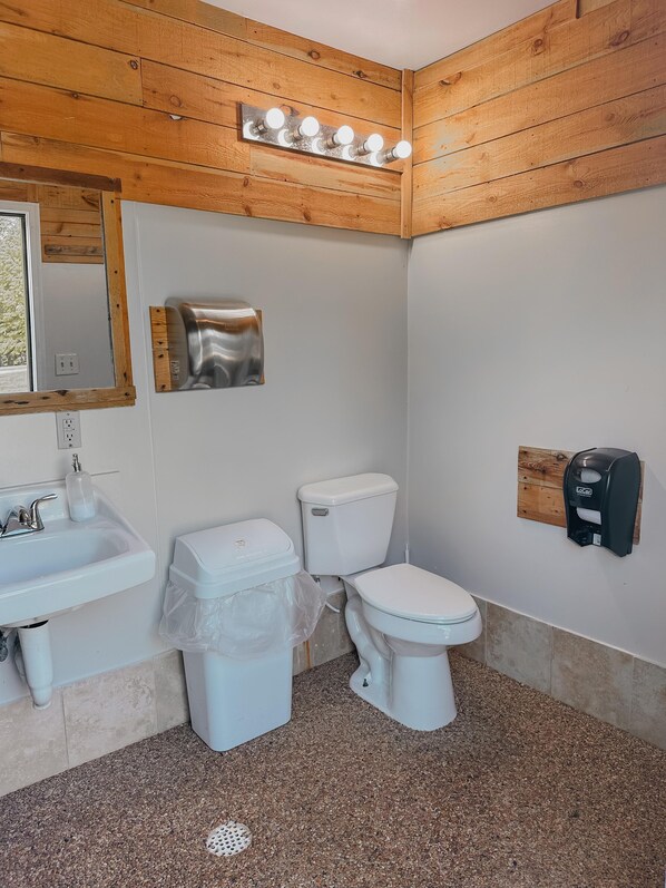 A bathroom with a wooden ceiling, a sink, a toilet, and a soap dispenser. - Robin Rustic Cabin - Robin Cabin rates are based on 5 guests, Maximum of 6 (Rockbridge)