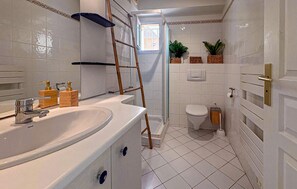 Un baño con lavamanos grande, inodoro y zona de ducha.