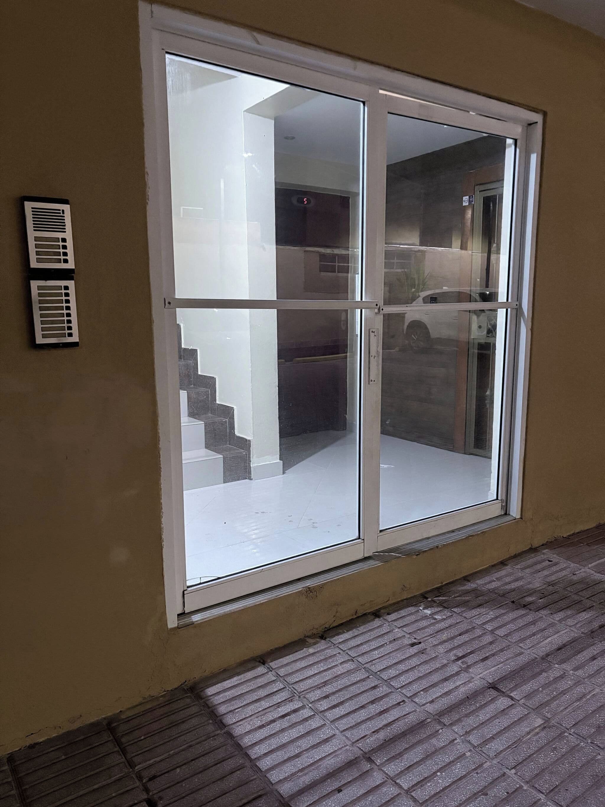 A sliding glass door with a view of a staircase and a parked car outside.