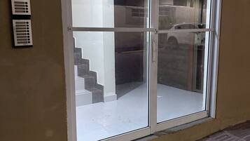 A sliding glass door with a view of a staircase and a parked car outside.