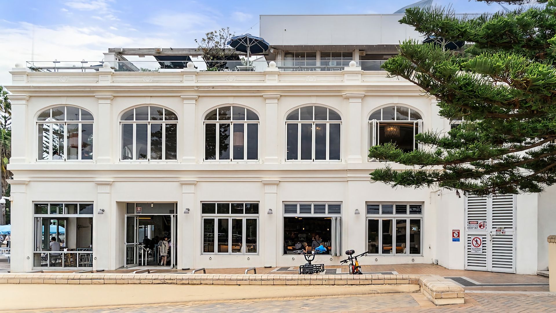 A two-story building with large windows and a ground-level entrance.