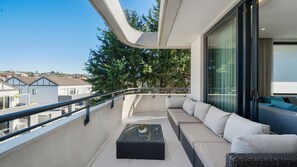 A balcony with a sofa, a small table, and a view of the surrounding area. - Sleek 1BR Apartment w Skylight near Coogee Beach (Coogee)