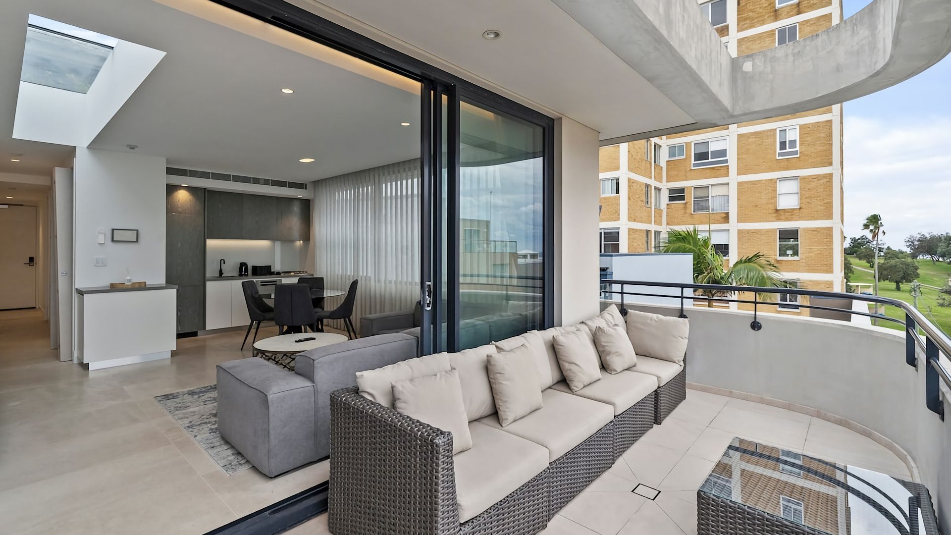 A modern apartment with a balcony, a dining area, and a kitchen.