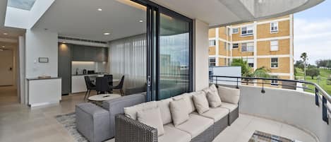 A modern apartment with a balcony, a dining area, and a kitchen.