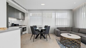 Une cuisine moderne avec un coin repas, un canapé et une table basse.