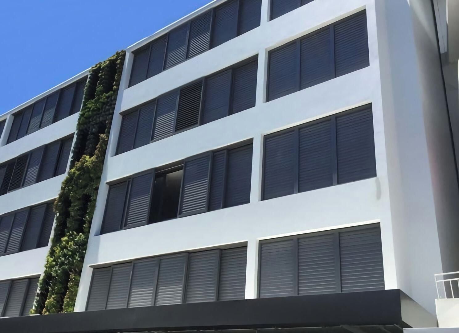 A multi-story building with a white facade and horizontal window lines.