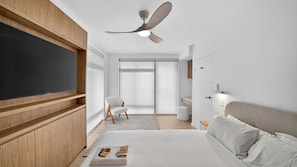A modern bedroom with a bed, a chair, a ceiling fan, and a TV mounted on the wall. - Spacious North Bondi Apt w Balcony near beach (Bondi Beach)
