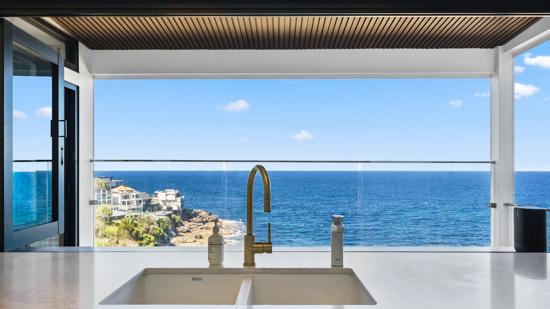 A modern bathroom with a large sink and a view of the ocean.