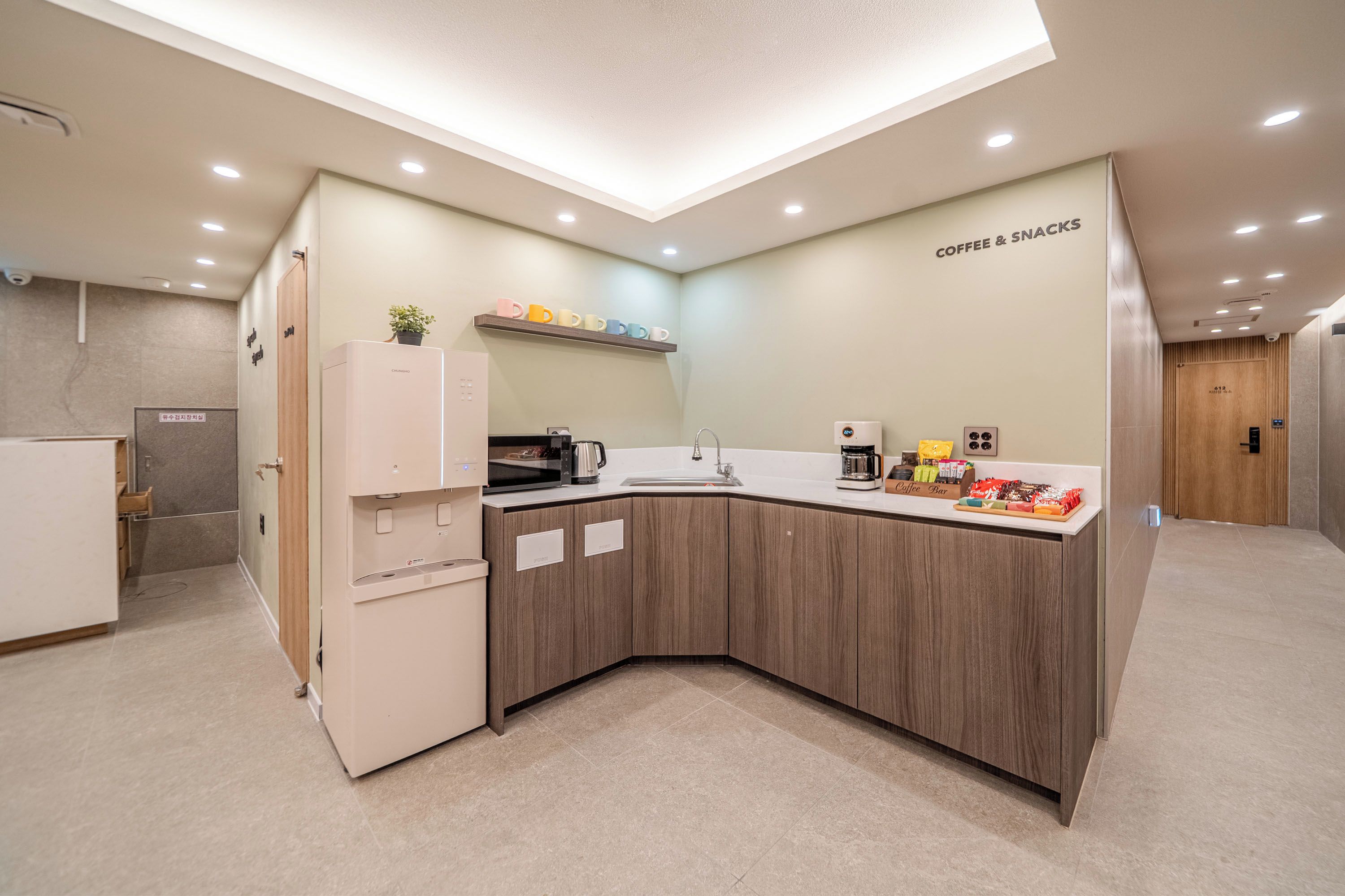 A modern kitchen with a built-in microwave, coffee maker, and a coffee bar.