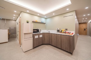 A modern kitchen with a built-in microwave, coffee maker, and a coffee bar. - Melo Stay Seoul (Seoul)