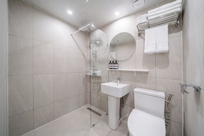 A modern bathroom with a glass-enclosed shower, a white sink, and a toilet. - Melo Stay Seoul (Seoul)