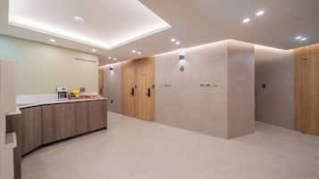 A modern hotel lobby with a coffee station, wooden lockers, and a clean, minimalist design.