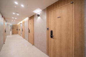 Pasillo de hotel con puertas de madera numeradas 604 y 603, provistas de lectores de tarjetas.
