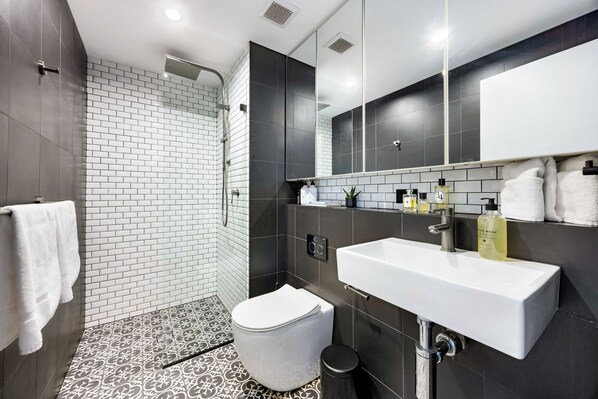 Une salle de bain moderne équipée d’une douche, de toilettes et d’un lavabo.