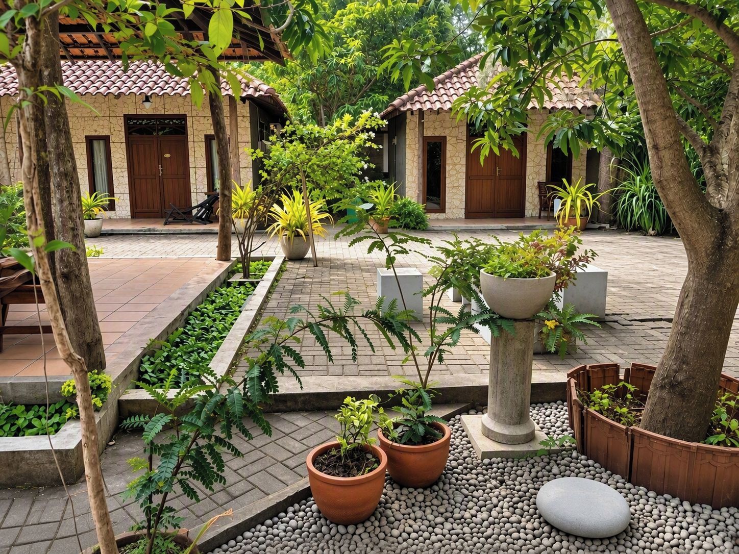 Un patio con plantas en macetas, un sendero de piedra y un edificio tradicional con techo de tejas.