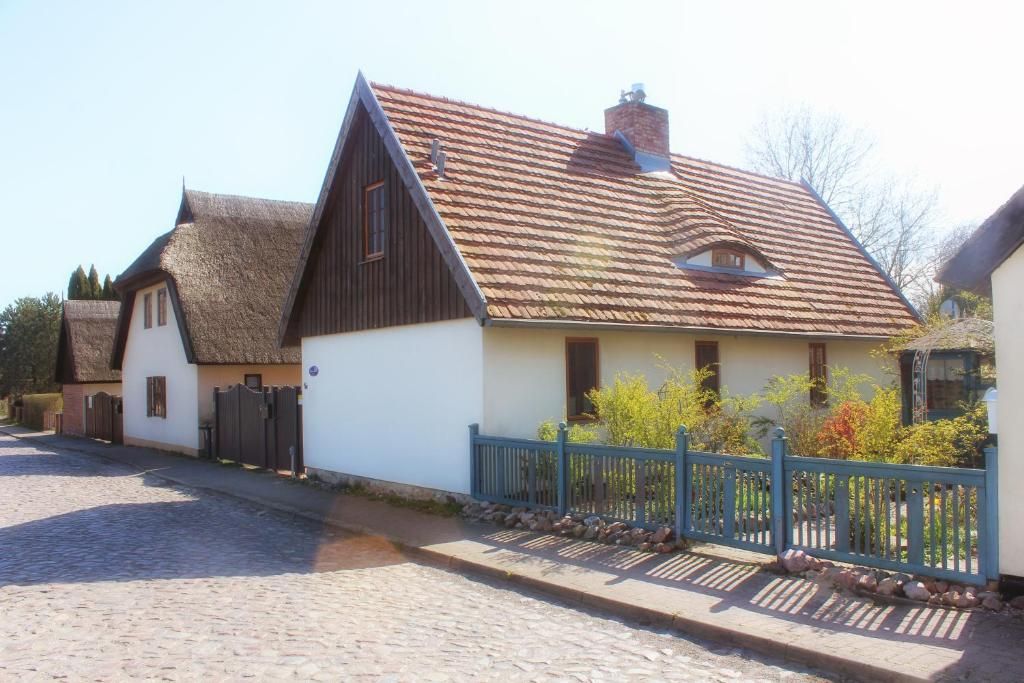 Un edificio de estilo europeo tradicional con un techo empinado y una extensión con tejado de paja.