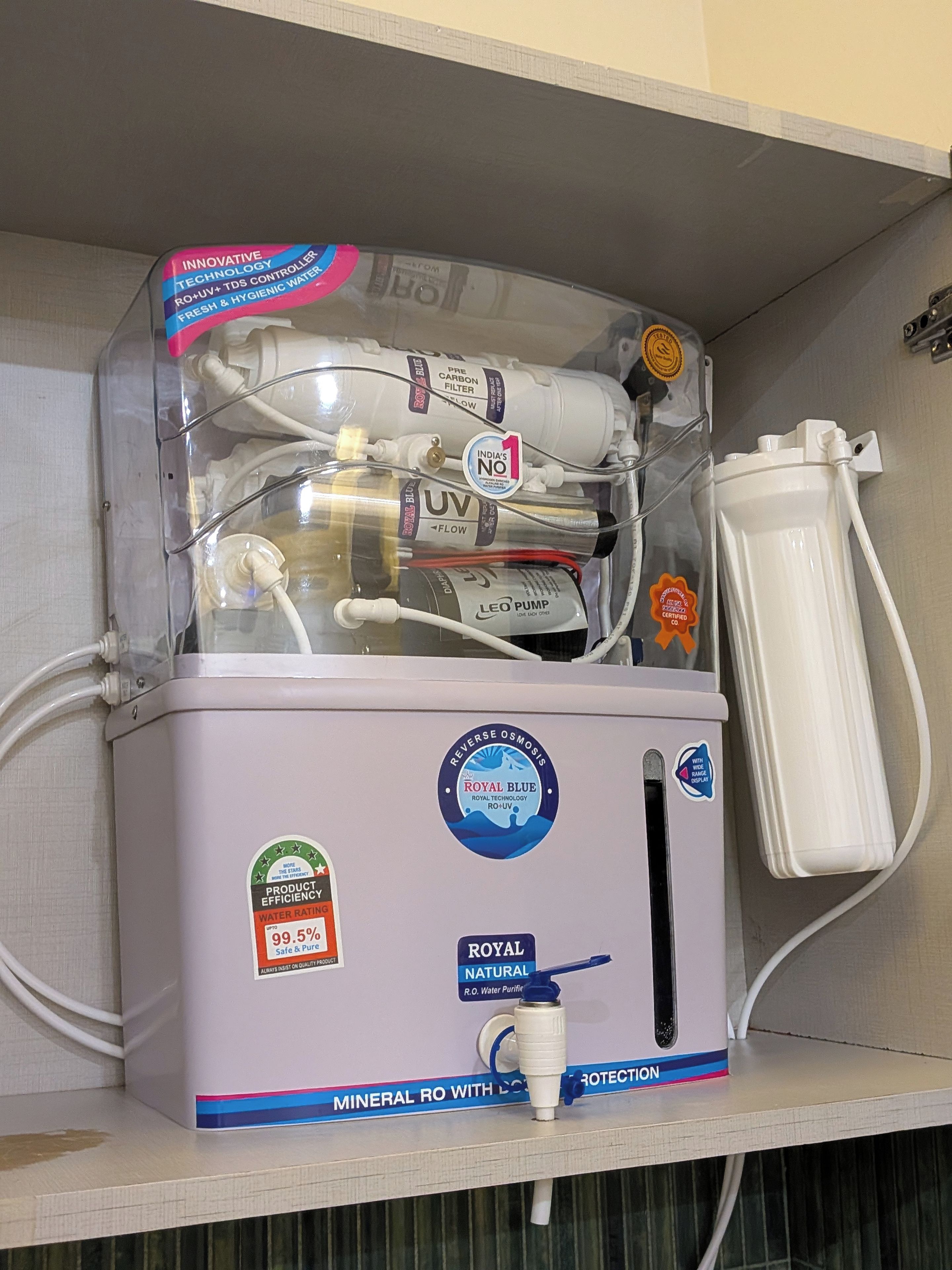 A water purifier with multiple filters and a display indicating a 99.5% water rating.