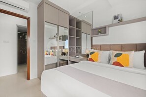 Ein modernes Schlafzimmer mit einem großen Bett, einem begehbaren Kleiderschrank und einem Badezimmer mit Dusche.