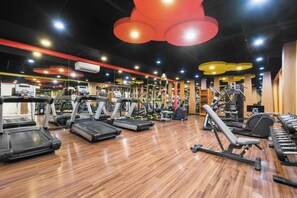 Ein Fitnessstudio mit Laufbändern, Crosstrainern und Kraftgeräten.