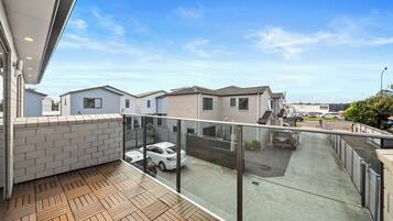 A residential area with modern houses, a covered parking area, and a clear sky.