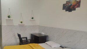 Una habitación de hotel con una cama, un escritorio y un ventilador de techo.