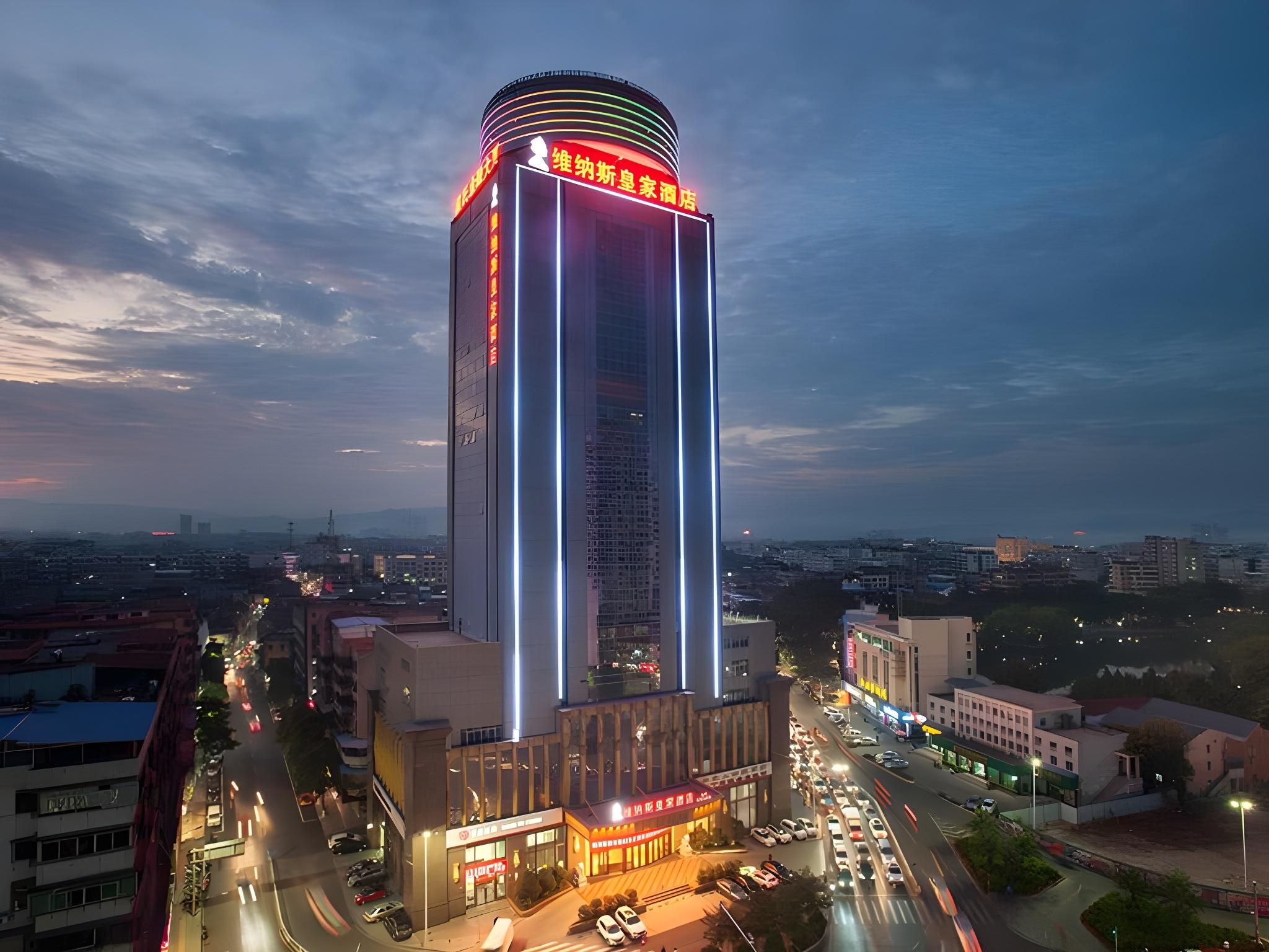 A tall hotel with a modern design, featuring a prominent vertical light strip and a circular top.