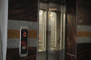 An elevator with a digital display indicating '0' and a button below it.