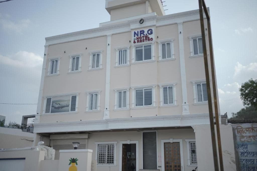 Un hotel de varios pisos con un letrero que dice 'NRG HOTEL & RESTRO'.