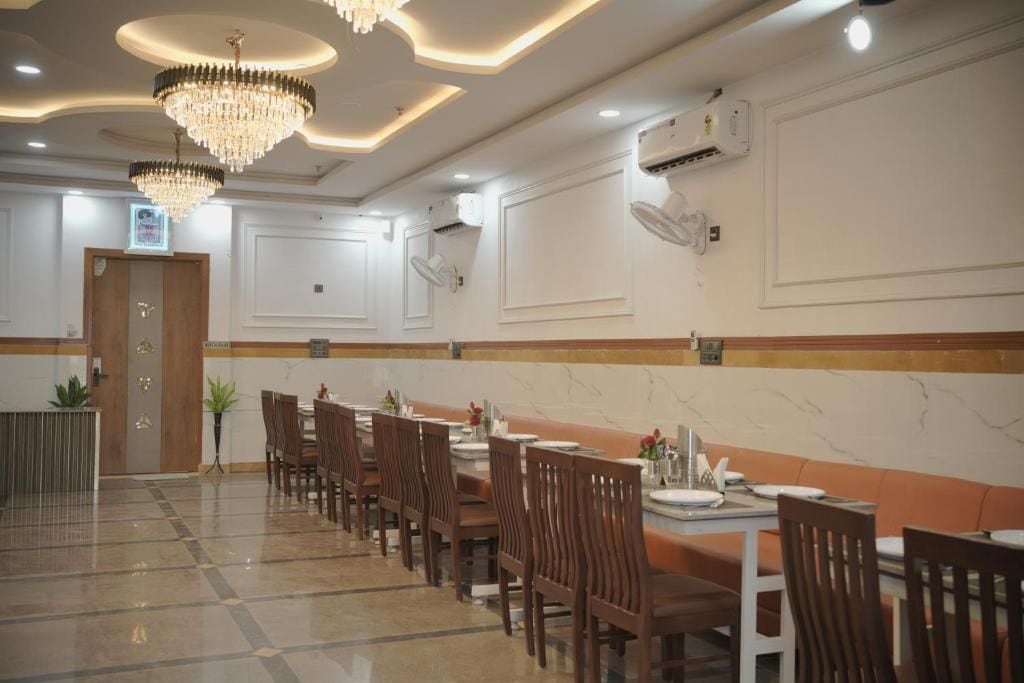 Un comedor con varias mesas y sillas, candelabros y un equipo de aire acondicionado en la pared.