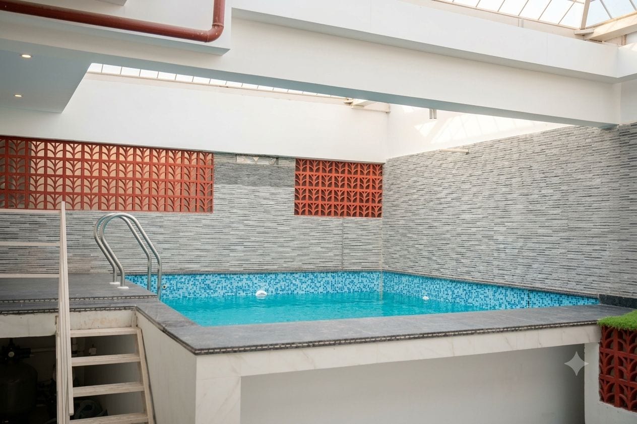 Una piscina con una escalera, rodeada de paredes con mosaicos y diseños geométricos.