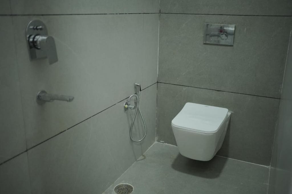 Un baño pequeño y moderno con inodoro, ducha y lavamanos.