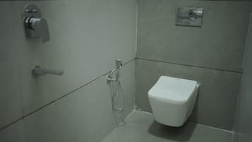 Un baño pequeño y moderno con inodoro, ducha y lavamanos.