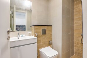 Ein Badezimmer mit Dusche, Waschbecken und Toilette.