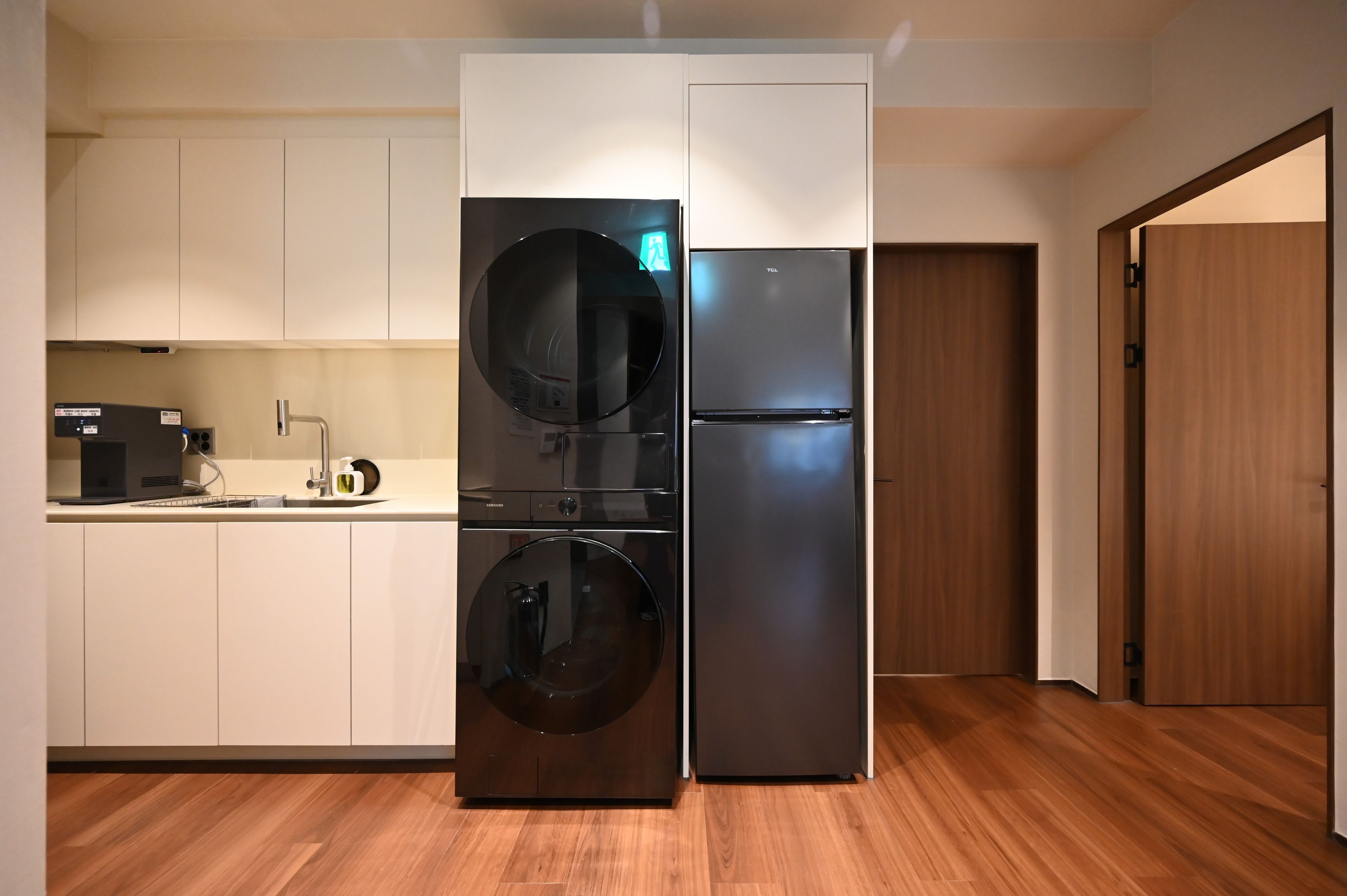 A compact kitchen with a built-in washer and dryer, a refrigerator, and a microwave.