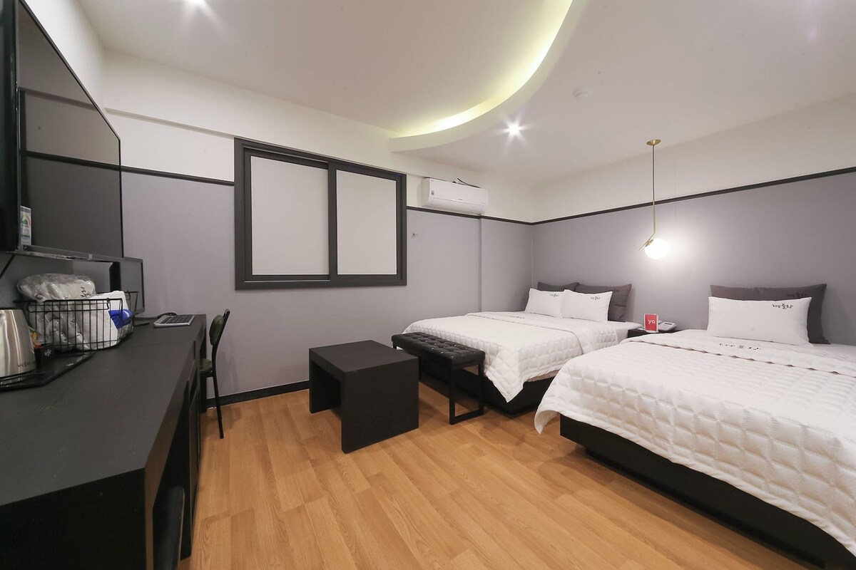Une chambre moderne avec deux lits, un bureau et une chaise.