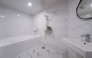 Une salle de bain moderne avec une baignoire, une douche et un lavabo.