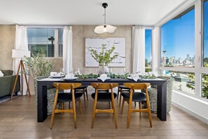 Ein Essbereich mit Tisch für vier Personen, Blick auf die Stadt und einem modernen Interieur.