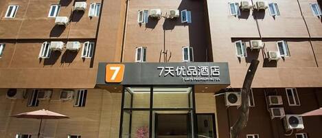 Ein Hotel mit einem gut sichtbaren Schild mit der Nummer 7, Klimaanlagen und einem Glastür.